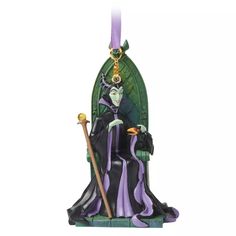 an ornament with a witch sitting on a chair