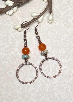 These boho everyday earrings, perfect not only for fall, but anytime of year, were created using orange dyed Quartzite gemstone beads, Serpentine Jasper heishi beads in light turquoise with splashes of orange and beige, small daisy spacer beads, and antique copper hammered connector hoops. Total length of earrings, including the ear wire, is approximately 2-1/2".  The hoops measure slightly less than 1" x 1". For matching bracelet, click on the link below: https://www.etsy.com/listing/1775405734/boho-gemstone-layered-bracelet-bohemian?click_key=dd7cc051989c2a01f33517f997db305a15f4ae31%3A1775405734&click_sum=2e4d6686&ref=shop_home_active_1&frs=1&sts=1 Thank you for shopping with The Lucie Collection! Adjustable Orange Hoop Earrings, Handmade Adjustable Rust Earrings, Bohemian Nickel-free Rust Earrings, Adjustable Nickel-free Rust-colored Jewelry, Bohemian Rust-colored Nickel-free Earrings, Adjustable Rust-colored Nickel-free Jewelry, Rust Color Dangle Earrings With Ear Wire, Rust Dangle Earrings With Ear Wire, Nickel Free Orange Hoop Earrings