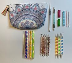 several pens, pencils, and markers are laid out on a white counter top