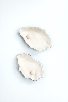 two pieces of white pottery sitting next to each other