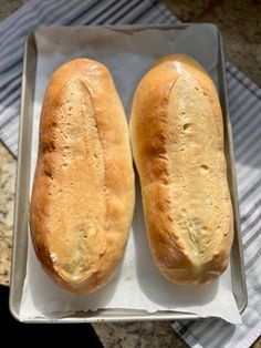 two loaves of bread sitting on top of a pan