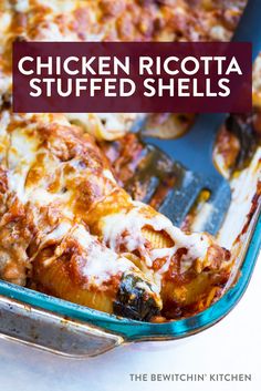 chicken ricotta stuffed shells in a blue casserole dish with a spatula