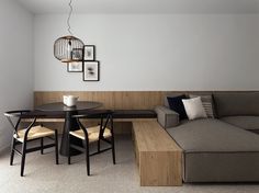 a living room with a couch, table and chairs next to a wall mounted light