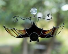 a stained glass bird decoration hanging from a window