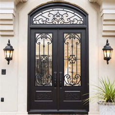 a black double door with two sidelights and wrought iron grills on the sides