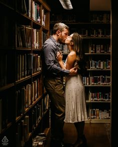 a man kissing a woman in front of a book shelf filled with shelves full of books