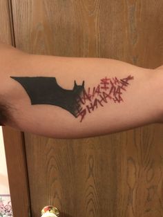 a person with a tattoo on their arm that says, make them happy and the word batman is written in red ink