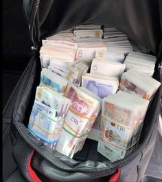 a suitcase filled with lots of money sitting on top of a floor