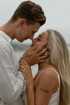 a man and woman standing next to each other with their hands covering their faces together