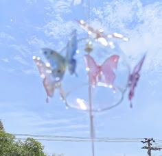 three glass butterflies are hanging from a pole