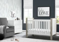 a baby's room with blue walls, white furniture and gray carpeted flooring