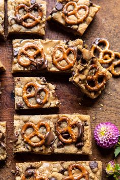 chocolate chip cookie bars with pretzels on top and flowers in the background, ready to be eaten