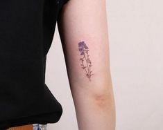 a woman with a tattoo on her arm has a flower tattooed on her left arm