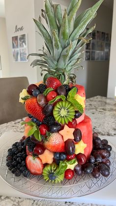 there is a cake made to look like a pineapple on top of fruit and berries