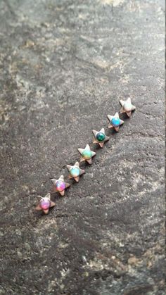 five star shaped opal studs on top of a rock