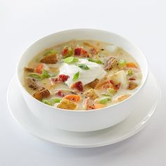 a white bowl filled with soup on top of a plate