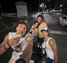 a group of people taking a selfie in the middle of the street at night