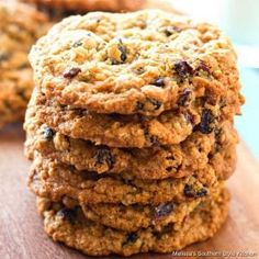 a stack of oatmeal cookies sitting on top of a wooden cutting board