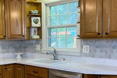 a kitchen with wooden cabinets and white counter tops