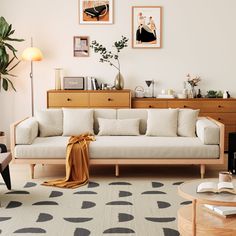 a living room filled with furniture and pictures on the wall next to a coffee table