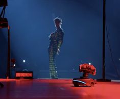 a man standing on top of a stage next to a fire hydrant in the dark