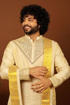 Gold pattu kurta featuring zari and cutdana hand embroidery on the neckline and sleeve hem. Paired with a dhoti pant and a kanduva. - Aza Fashions Festival Cotton Silk Bandhgala With Dupatta, Ceremonial Raw Silk Kurta With Cutdana, Tussar Silk Sherwani For Diwali Festive Occasions, Ceremonial Tussar Silk Kurta With Zari Work, Ceremonial Tussar Silk Kurta With Traditional Drape, Cotton Silk Churidar For Ceremonial Festivals, Tussar Silk Sherwani For Festivals, Ceremonial Cotton Silk Churidar For Festivals, Ceremonial Cotton Silk Bandhgala With Zari Work