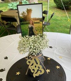 a hat with flowers in it on top of a white table cloth covered tablecloth