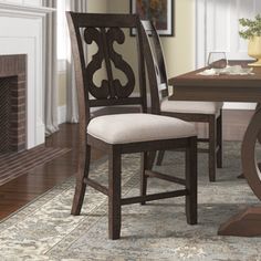 a dining room table and chairs with a fireplace in the background