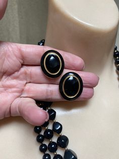 "Some ladies like only pearls. Others like bright colored pieces of jewelry. And you might be the lady who, like me, likes black jewelry. For that reason I have compiled 3 black and gold bead necklace with a pair of black and gold clip on earrings to wear together or in any arrangement you might like. Especially nice for the lady who wears lots of black and white clothing and is always looking for jewelry to go with. The longest necklace doesn't have any gold beads. Spring ring clasp. Knotted be Black Jewelry With Matching Earrings For Evening, Black Jewelry Set With Matching Earrings For Evening, Black Metal Costume Jewelry Earrings, Vintage Black Jewelry With Matching Earrings, Black Necklaces With Matching Earrings For Party, Black Necklace With Matching Earrings As Gift, Vintage Black Beaded Jewelry, Black And White Clothing, Black Gold Earrings