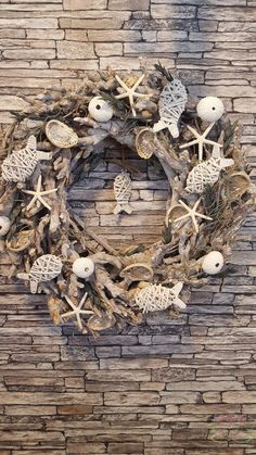 a wreath made out of sea shells on a brick wall