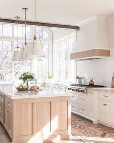 a large kitchen with white cabinets and an island in the middle of the room is shown