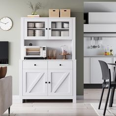 a white hutch sitting in the middle of a living room next to a table