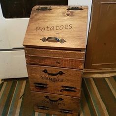 a wooden box with writing on it sitting in front of a stove and microwave oven