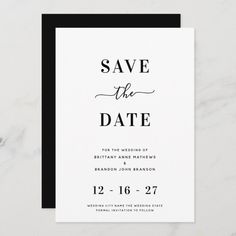 the black and white save the date card is on top of a marble surface, with an elegant calligraphy font