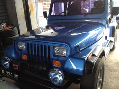 a blue jeep is parked in a garage