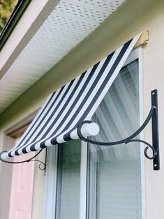 a black and white striped awning hanging from the side of a house