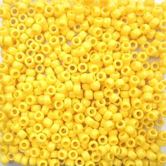 yellow plastic beads are arranged on a white surface