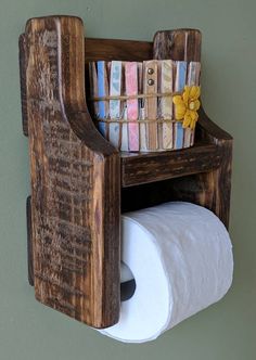 a toilet paper holder made out of wood with a basket on top and two rolls of toilet paper in it