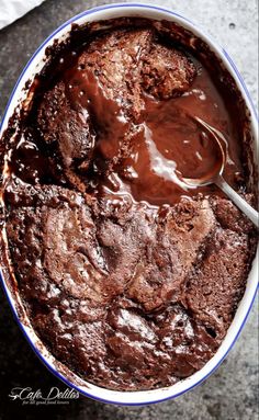 a chocolate cake in a bowl with a spoon