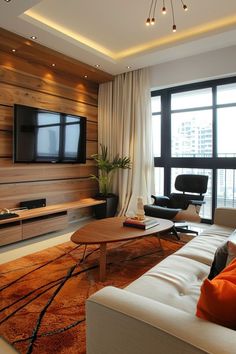 a living room with couches, chairs and a flat screen tv on the wall