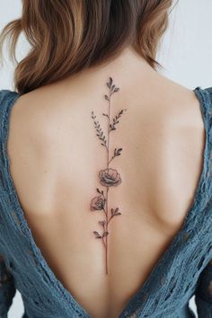 the back of a woman's neck with flowers and leaves on her left side