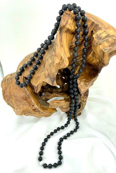 "This handcrafted, hand knotted, mala style necklace features lava, matte black onyx and white jade. Black onyx promotes strength, stamina, and constancy along with the lava which gives inspiration, creativity, and peace.  Jade is an amulet of good luck.  Jade aids in emotional and spiritual healing as well as promotes courage, wisdom, stability, longevity, and fertility. This necklace has a high quality S-Lon core.  Necklace is 46.5\" (see photos). Please Note: 1. Colors may vary slightly due t Black Lava Stone Necklace For Gift, Black Lava Stone Round Bead Necklaces, Black Lava Stone Necklace Spiritual Style, Black Necklaces With 8mm Beads For Meditation, Onyx Bead Necklaces For Meditation, Onyx Black Beaded Necklace For Meditation, Black Gemstone Beads Necklace For Meditation, Onyx Necklace With Black Beads For Meditation, Black Mala With 8mm Beads For Healing