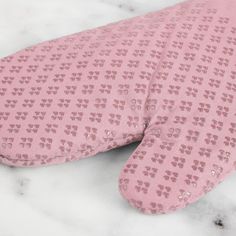 a pink neck pillow laying on top of a marble surface