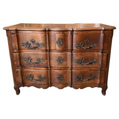 an old wooden dresser with many drawers on it's sides and carvings around the top