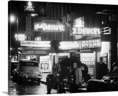 an old black and white photo of people walking down the street in front of some stores