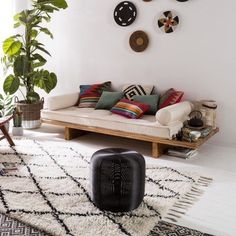 a living room filled with furniture and lots of pillows on top of the rugs