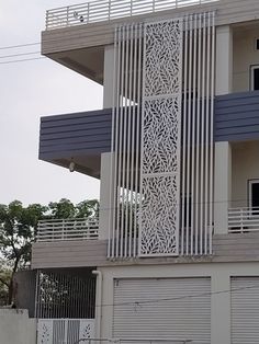 a tall white building with a clock on the side of it's face and balconies