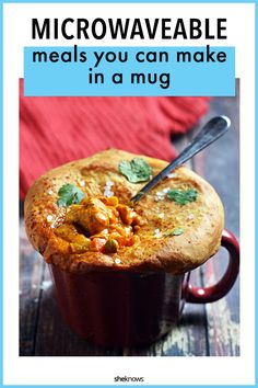 a red mug filled with food on top of a wooden table