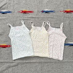 Add a touch of retro charm to your child's wardrobe with this set of three vintage 70s floral tank tops from Sears. Includes one blue, one yellow, and one pink tank top, all crafted from 100% cotton for comfort and breathability. Features: Authentic vintage 1970s design Set of 3: Blue, Yellow, and Pink Made from soft, durable 100% cotton Perfect for size L (6/6x) Measurements: Chest: 22" - 30" Length: 16.5" These tops are ideal for layering or wearing on their own during warm weather. Embrace the timeless floral patterns and vibrant colors that make these tops stand out. Whether for everyday wear or a special occasion, these tank tops are sure to be a favorite. 1970s Design, 70s Floral, Yellow And Pink, Floral Tank Top, Pink Tank, Floral Tank, Pink Tank Top, Design Set, Kids Tops