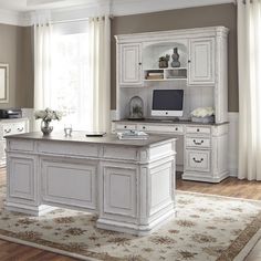 a large white desk sitting in the middle of a living room next to a window